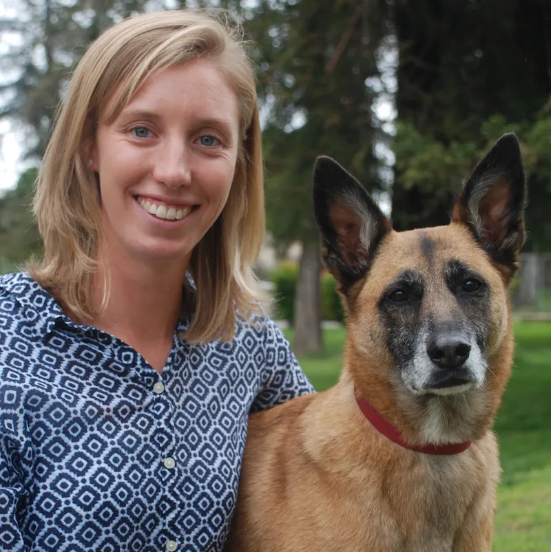 Smiling woman with a Belgian Malinois dog.